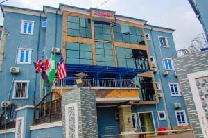 un edificio azul con dos banderas delante en E45 Hotels and Suites en Owerri