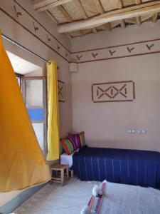 sala de estar con sofá azul y ventana en Maison d'hôtes IZZA, en Kalaat MGouna
