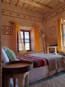 um quarto com uma cama grande e uma janela em Maison d'hôtes IZZA em El Kelaa des Mgouna