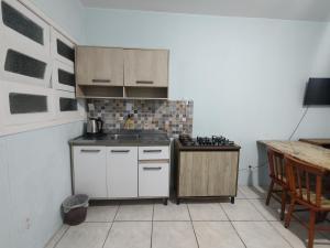 a small kitchen with a sink and a stove at Pousada Golfinhos in Imbé