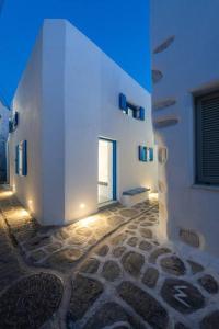 a white building with a door and a stone courtyard at Blue Paros House Paroikia Center close to port in Kampos Paros