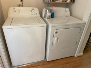 two white appliances sitting next to a washer and dryer at Sperryville 3 BR house next to Blue Ridge Mts. in Sperryville