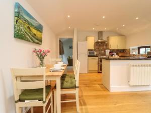 a kitchen and dining room with a table and chairs at Little Tregarrick in Helston