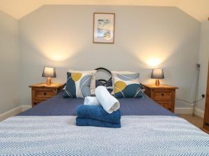 a bedroom with a bed with blue and yellow pillows at Little Tregarrick in Helston
