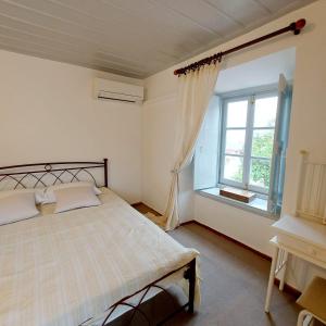 a bedroom with a large bed and a window at Danaë Port House in Hydra