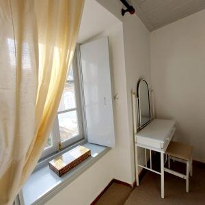 a bathroom with a sink and a window with a mirror at Danaë Port House in Hydra