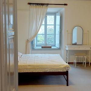 a bedroom with a bed and a window at Danaë Port House in Hydra