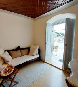 a living room with a couch and an open door at Danaë Port House in Hydra