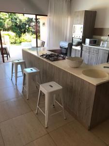 a kitchen with two stools and a counter with a sink at A80@VIPINGO RIDGE in Kilifi