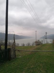 a field with a fence and a view of the water at Vikendica Dunav i SAVA in Donji Milanovac