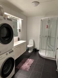 a bathroom with a washing machine and a toilet at Vardø accommodation - white house in Vardø