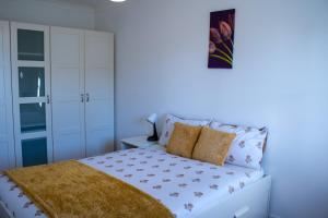 a bedroom with a white bed with a yellow blanket at Charming 2-Bed Fully Furnished Apartment in London in London