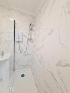 uma casa de banho branca com um chuveiro e um WC. em Belvedere House 2 bedroom Greater London em Belvedere