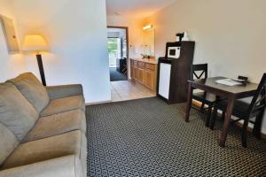 a living room with a couch and a table and a kitchen at Nader's Motel & Suites in Ludington