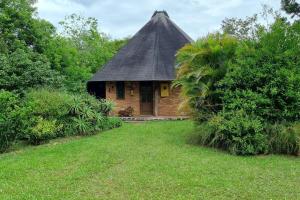 a small brick building with a thatched roof at Cabana no Rincão Gaia in Pântano Grande