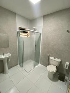 a bathroom with a shower and a toilet and a sink at Pousada Manaíra in João Pessoa