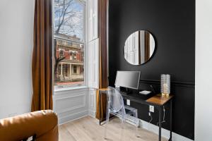 Cette chambre comprend un bureau avec un ordinateur et une fenêtre. dans l'établissement Northside Pittsburgh Luxurious Apartment, à Pittsburgh