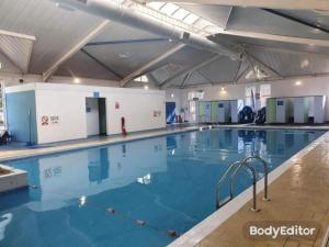 a large indoor swimming pool with blue water at 11 Oaklands in Porchfield
