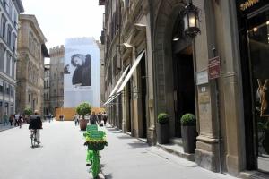 two people riding bikes down a city street at Tornabuoni TOT - luxury apartments in Florence