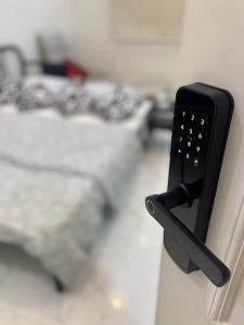 a remote control hanging on a wall next to a bed at Eco Room in Jeddah