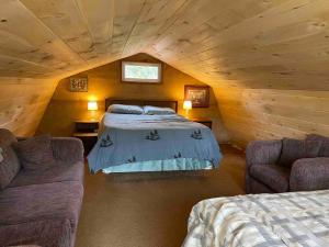 a bedroom with a bed and two couches in a attic at Hocking Hills Cottage with beautiful pond in Logan +23 photos