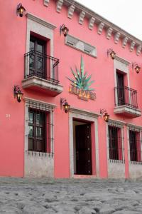 un edificio rosa con una pianta sul davanti di Nueve Agaves Hotel a Tequila
