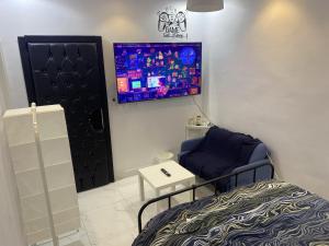 a bedroom with a bed and a tv on the wall at Eco Room in Jeddah