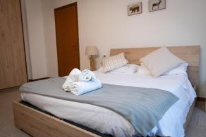 1 dormitorio con 1 cama con toallas en Luna al Monte en Cuasso Al Monte