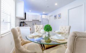 a kitchen and dining room with a glass table and chairs at King-Size Bed, Parking Free Near Brickell & Grove in Miami