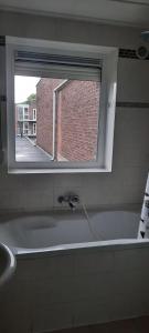 ein Badezimmer mit Badewanne und Fenster in der Unterkunft SIMLA INDIAAS RESTAURANT VOOR KAMER in Sittard + 2 Fotos
