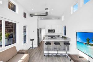 a kitchen with white walls and a kitchen island with bar stools at Tiny Home on Waterfront, Bay Views, Deck, Pool in Jewfish