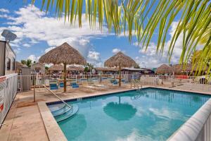 uma piscina com guarda-sóis de palha e espreguiçadeiras em Tiny Home on Waterfront, Bay Views, Deck, Pool em Jewfish