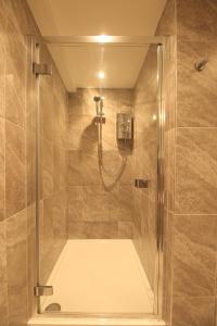 a shower with a glass door in a bathroom at Streamside Apartments in Yeovil