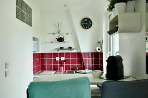a kitchen with red tiles and a table and a clock at Pegase in Deauville +28 photos