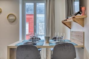a dining room table with chairs and wine glasses at App Le Galet 5min du port in Fécamp