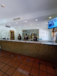 three people standing at a bar in a hotel at Hotel Margarita Village in Porlamar