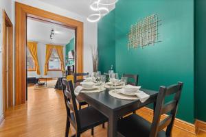une salle à manger avec une table noire et un mur vert dans l'établissement Northside Pittsburgh Newly Remodeled, à Pittsburgh