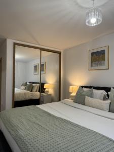 a bedroom with a large bed and a mirror at Luxury Apartment in Dartford in Dartford