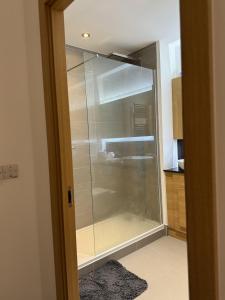 Luxury Apartment in Dartford في دارتفورد: عليك المشي من الزجاج في الحمام في المطبخ