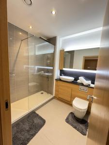 a bathroom with a shower and a toilet and a sink at Luxury Apartment in Dartford in Dartford