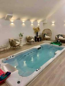 una gran bañera de hidromasaje en una sala de estar con sillas en Island Seaview Villa with Swim Spa & Sauna, en Rothesay