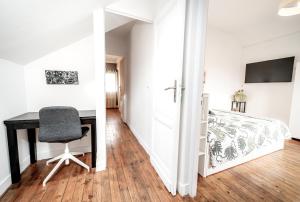 um quarto com uma secretária e uma cama em Le Domaine du petit Basque em Talence