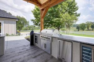 an outdoor kitchen with a grill on a deck at Majestic Manor-Private Hundred Acre Yard-Pool/Spa in Lebanon
