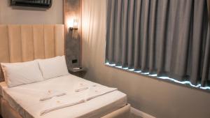 a small bedroom with a bed with a window at TALLES CITY HOTEL in Konak