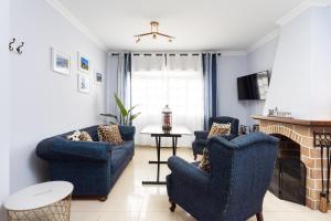salon z niebieskimi krzesłami i kominkiem w obiekcie Apartamento Renovado "Hogar Las Vistas" w mieście Los Realejos