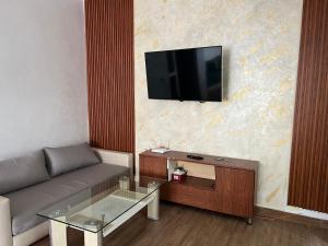 a living room with a couch and a tv on a wall at Casablanca heart of town apartment in Casablanca