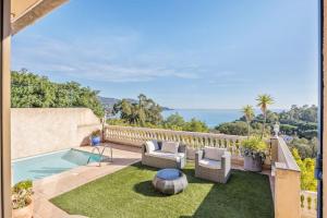 un patio al aire libre con sillas y una piscina en Villa Piscine, vue mer Cap Nègre, en Le Lavandou