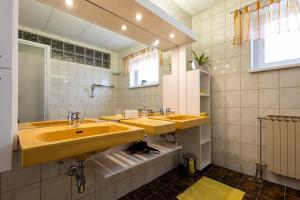 a bathroom with two sinks and a large mirror at Appartementhaus Elfi in Barnbäch