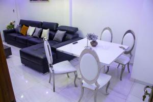 Happyhomes في داكار: غرفة معيشة مع أريكة وطاولة وكراسي