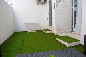 Happyhomes في داكار: شرفة صغيرة مع عشب أخضر ونافذة